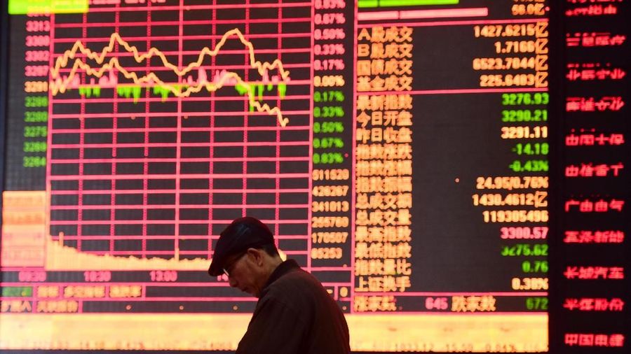 A man is seen against an electronic board showing stock information at a brokerage house in Fuyang, Anhui province, China March 16, 2018. REUTERS/Stringer  ATTENTION EDITORS - THIS IMAGE WAS PROVIDED BY A THIRD PARTY. CHINA OUT.
