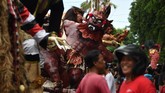 Wisatawan dan masyarakat sekitar menyaksikan parade Ogoh-Ogoh jelang Hari Raya Nyepi di Denpasar, Bali. Hari Raya Nyepi sendiri digelar hari ini, Sabtu (17/3). (AFP PHOTO / Sonny Tumbelaka)