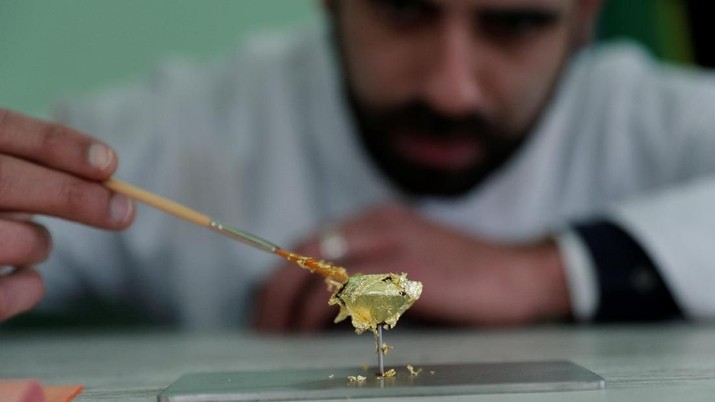 Portuguese chocolatier Daniel Gomes prepares a candy wrapped in pure 23 carat gold during international chocolate fair in Obidos  Portugal, March 16, 2018. REUTERS/Rafael Marchante