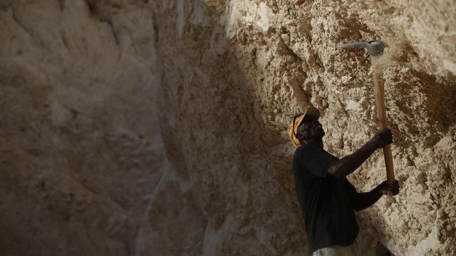 A man uses a pick to break rocks and get sand in a sand mine on the outskirts of Fond Parisien, Haiti March 21, 2018. REUTERS/Andres Martinez Casares