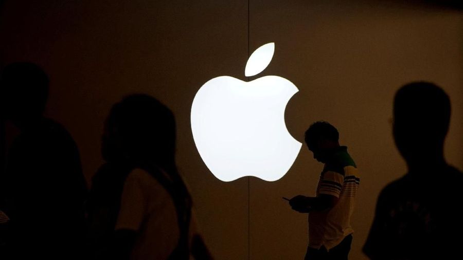 FILE PHOTO: A man looks at the screen of his mobile phone in front of an Apple logo outside its store in Shanghai, China on July 30, 2017.   REUTERS/Aly Song/File Photo