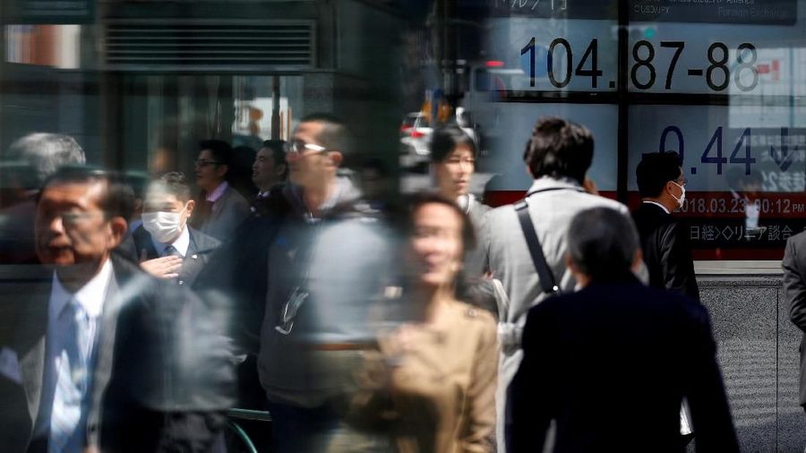 People walk past an electronic board showing exchange rate between Japanese Yen and U.S. Dollar outside a brokerage at a business district in Tokyo, Japan, March 23, 2018. REUTERS/Toru Hanai TPX IMAGES OF THE DAY