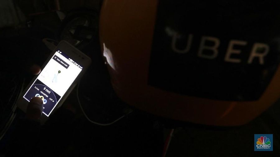 Driver Uber melintas di kawasan Arteri Jakarta Selatan, Senin (26/3). Grab resmi mengakuisisi seluruh bisnis Uber di Asia Tenggara. Manajemen mengklaim merger ini akan dapat meningkatkan inklusifitas dan kemudahan akses. (CNBC Indonesia/Muhammad Sabki)