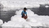 Apalagi itu diselenggarakan di berbagai sungai di India. Di New Delhi, festival itu digelar di Sungai Yamuna yang penuh polusi. Terlihat anak-anak bermain dengan busa. (REUTERS/Adnan Abidi)