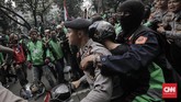 Di tengah aksi, sempat terjadi insiden. Peserta demo mengepung rekan mereka sesama pengemudi ojek yang tak ikut demo dan kedapatan membawa penumpang melewati peserta aksi. (CNN Indonesia/Adhi Wicaksono)