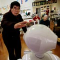 Seorang warga mendekati robot humanoid 'Pepper' untuk menepuk kepalanya selama rutinitas latihan sore di rumah perawatan Shin-tomi di Tokyo, Jepang, 2 Februari 2018. REUTERS / Kim Kyung-Hoon