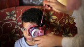 Alaa Abu Mustafa juga membuat mata seorang anak laki-laki jadi seakan berdarah-darah. (REUTERS/Ibraheem Abu Mustafa)