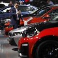 A man photographs BMW cars on display at the New York Auto Show in the Manhattan borough of New York City, New York, U.S., March 28, 2018. REUTERS/Brendan McDermid