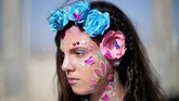 Seorang perempuan dilukis dengan cantik, wajahnya jadi berbunga-bunga. (REUTERS/Ibraheem Abu Mustafa)