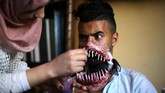 Itu berkat Alaa Abu Mustafa, seorang perias yang seakan bisa membuat ilusi apa saja pada wajah dan tubuh orang. (REUTERS/Ibraheem Abu Mustafa)