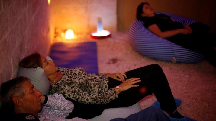 A group sits in the salt cave during a meditation session in Amman, Jordan, March 28, 2018. Picture taken March 28, 2018. REUTERS/Muhammad Hamed