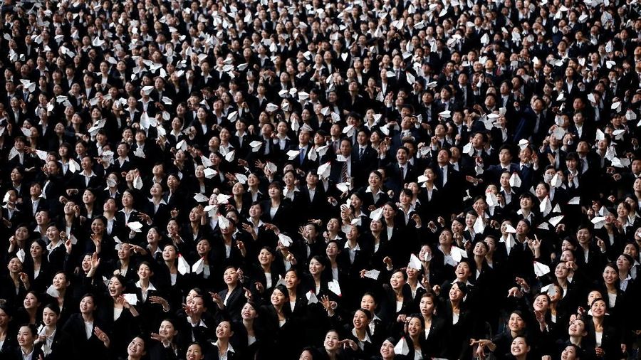 Newly-hired employees of Japan Airlines (JAL) group fly paper planes during the company group's initiation ceremony at a hangar of Haneda airport in Tokyo, Japan, April 2, 2018. REUTERS/Issei Kato