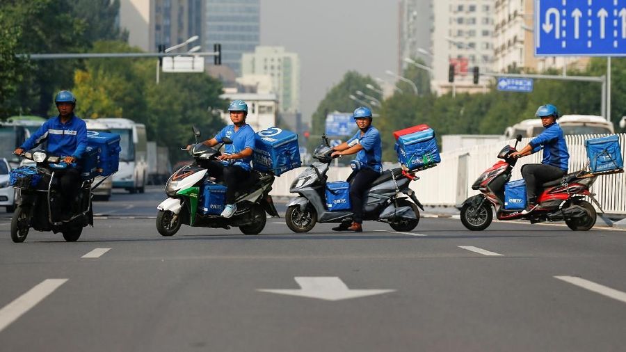 FILE PHOTO: Drivers of the food delivery service Ele.me after an internal security check before their morning shift in Beijing, China, September 21, 2017.  REUTERS/Thomas Peter/File Photo