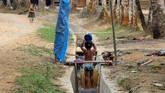 Seorang anak mandi di halaman rumahnya di Desa Melidi. Empat dari delapan desa yang terdapat di Kecamatan Simpang Jernih belum tersalurkan arus listrik dari PLN sejak daerah itu berdiri pada tahun 1919. (Anadolu Agency-Khalis Surry).