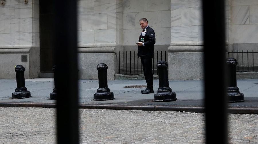 A trader stands outside the New York Stock Exchange (NYSE) in New York, U.S., April 2, 2018. REUTERS/Shannon Stapleton