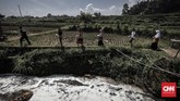 Warga melintasi di sekitar sungai Cikacembang yang merupakan anak sungai Citarum, Sabtu (31/3). Buih busa dan bau menyengat menjadi pemandangan sehari-hari warga sekitar.(CNNIndonesia/Adhi Wicaksono).