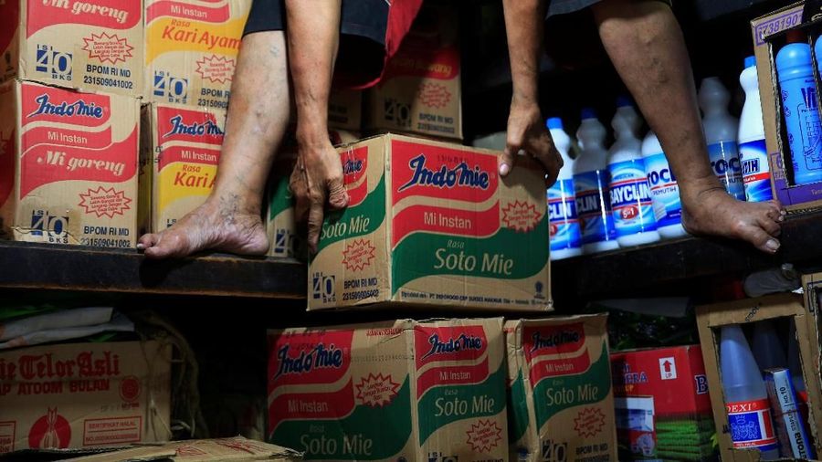 A worker holds instant noodle packs at a market in Jakarta, Indonesia, March 12, 2018. Picture taken March 12, 2018. REUTERS/Beawiharta