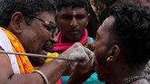 Pengarakan arca itu merupakan momen sakral yang menandakan penghormatan terhadap Dewa Muruga. Saat itu pula ada ritual ekstrem. Para umat Hindu menusuk kening, pipi serta badan mereka dengan jarum dan busur panah besi. (Khalis Surry - Anadolu Agency)