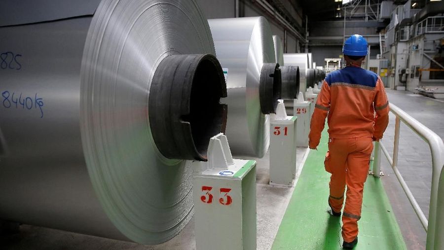 A worker walks along coils of aluminium at the Neuf-Brisach Constellium aluminium products company's production unit in Biesheim, Eastern France, April 9, 2018.  REUTERS/Vincent Kessler