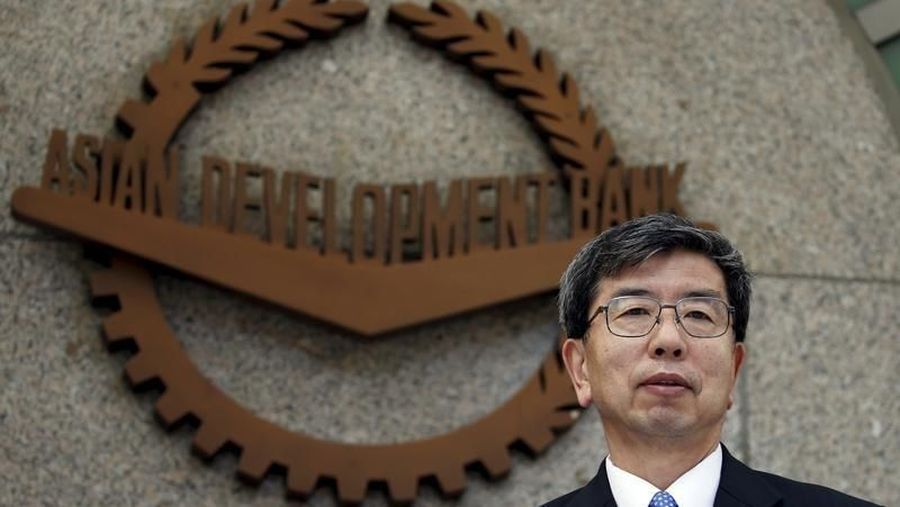 Asian Development Bank (ADB) President Takehiko Nakao poses in front of the logo of ADB at its headquarters in Mandaluyong, Metro Manila after a forum with members of the Foreign Correspondents Association of the Philippines January 8, 2016. REUTERS/Erik De Castro