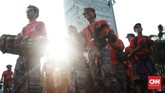 Tak peduli matahari terik, mereka meliuk di antara pejalan kaki yang menikmati CFD. (CNN Indonesia/Andry Novelino)