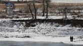 Warga Korut di tepi Sungai Yalu, dekat Linjiang, China. Sekelompok warga Korut juga menyelam di Sungai Yalu untuk mencari emas. (REUTERS/Damir Sagolj)