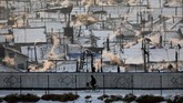 Seorang pria Korut mengendarai sepeda di tepian Sungai Yalu, Hyesan, Korea Utara dipotret dari sisi China. (REUTERS/Damir Sagolj