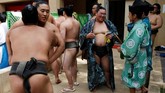Tawa, sinar matahari, dan optimisme memenuhi upacara turnamen Festival Sumo Musim Semi yang diselenggarakan di sebuah kuil perang Yasukuni Jinja di Tokyo pada Senin (15/4). (REUTERS/Toru Hanai)