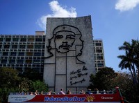 Tourists enjoy a ride on a double decker bus as they pass by a sculpture depicting revolutionary leader Che Guevara in Havana, Cuba, April 12, 2018. Picture taken on April 12, 2018. REUTERS/Alexandre Meneghini