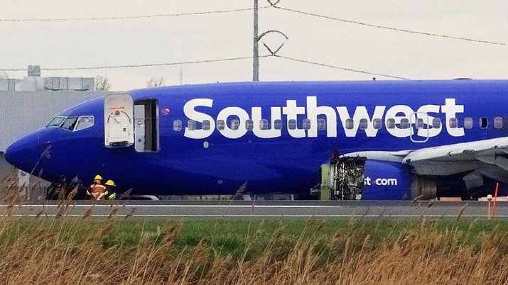 Emergency personnel monitor the damaged engine of Southwest Airlines Flight 1380, which diverted to the Philadelphia International Airport this morning after the airline crew reported damage to one of the aircraft's engines, on a runway in Philadelphia, Pennsylvania U.S. April 17, 2018.  REUTERS/Mark Makela