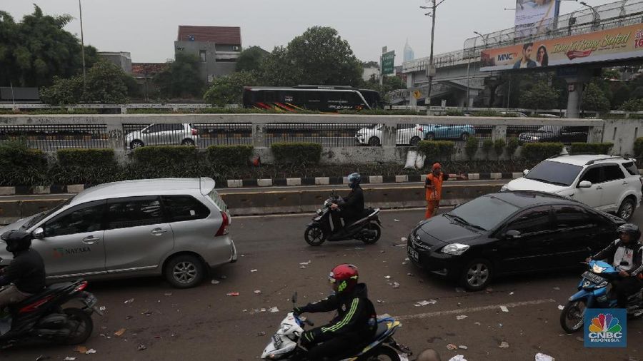Para pasukan orange membersihkan sampah yang berserakan di jalanan usai para pendemo membubarkan diri.