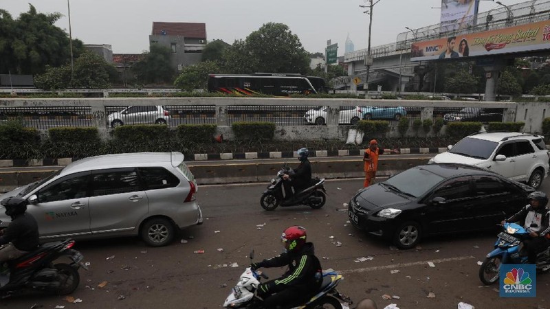 Para pasukan orange membersihkan sampah yang berserakan di jalanan usai para pendemo membubarkan diri.