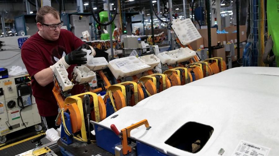 General Motors assembly workers connect a battery pack underneath a partially assembled 2018 Chevrolet Bolt EV vehicle on the assembly line at  Orion Assembly in Lake Orion, Michigan, U.S., March 19, 2018.  Photo taken March 19, 2018.   REUTERS/Rebecca Cook