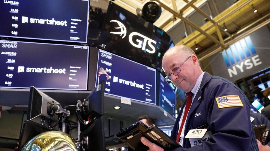A trader passes by the post, where Smartsheet Inc. hosts it's IPO, on the floor of the New York Stock Exchange (NYSE) in New York, U.S., April 27, 2018. REUTERS/Brendan McDermid