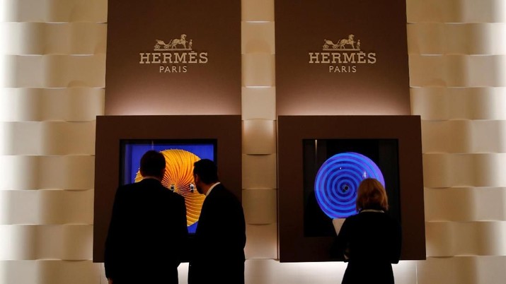 FILE PHOTO: Visitors look at Hermes watch models at the 