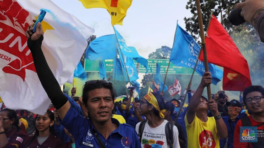 Massa dari berbagai aliansi buruh menyalakan flare atau gas asap sebelum membubarkan diri usai berorasi di depan Istana Negara, Jakarta.