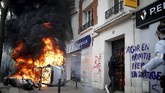 Sementara mobil terbakar ini berada di luar garasi Renault di Paris, sementara bentrokan terjadi di tengah demonstrasi serikat buruh. (REUTERS/Christian Hartmann)