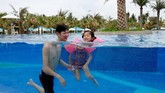 Pengunjung hotel Lin Hongyu berenang dengan putrinya yang berusia tiga tahun di kolam renang resort Atlantis Sanya, Provinsi Hainan, China. (Reuters/Bobby Yip)