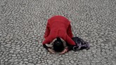 Seorang umat Buddha bersujud di depan situs Sekolah Beichuan yang terkubur dalam bencana gempa pada 2008 di Provinsi Sichuan, China. (Reuters/Jason Lee)