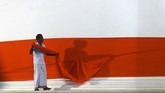 Seorang penganut Budha di Sri Lanka sedang menghiasi stupa menggunakan kain safron, jelang perayaan Waisak di kuil Kataragama Kiriwehara. Saat Waisak, para penganut agama Budha merayakan hari lahirnya Budha, pencerahan yang ia terima, dan kematiannya. (AFP/Ishara S. Kodikara)