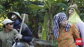 Sebagian dari mereka membawa orang-orangan sawah yang biasa dipasang di tengah padi yang sudah menguning untuk menakuti hama. (CNN Indonesia/Tri Wahyuni)