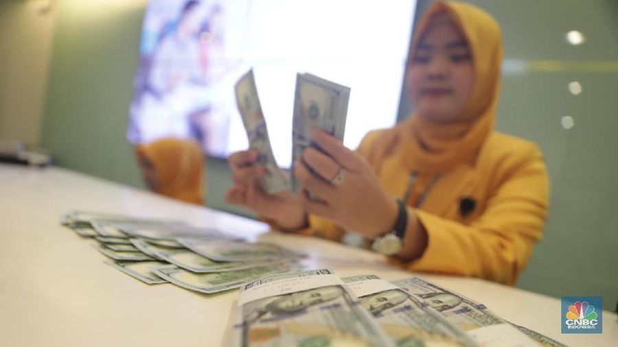 Ilustrasi Rupiah dan Dollar di teller Bank Mandiri, Jakarta, Senin (07/5). Nilai tukar rupiah terhadap dolar Amerika Serikat (AS) masih melemah. Rupiah melemah 0,32 % dibandingkan penutupan akhir pekan lalu. Harga jual dolar AS di  bank Mandiri Rp. 14.043. (վ/Muhammad Sabki)