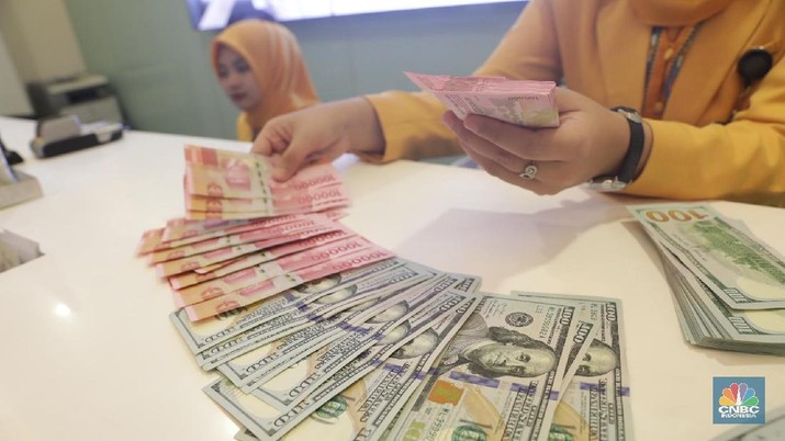 Ilustrasi Rupiah dan Dollar di teller Bank Mandiri, Jakarta, Senin (07/5). Nilai tukar rupiah terhadap dolar Amerika Serikat (AS) masih melemah. Rupiah melemah 0,32 % dibandingkan penutupan akhir pekan lalu. Harga jual dolar AS di  bank Mandiri Rp. 14.043. (CNBC Indonesia/Muhammad Sabki)