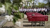 Belasan sisa jenazah yang ditemukan kelompok pencari akhirnya dimakamkan di desa yang sama dengan tempat kematian mereka, pada 5 Mei. (REUTERS/Eduard Korniyenko)