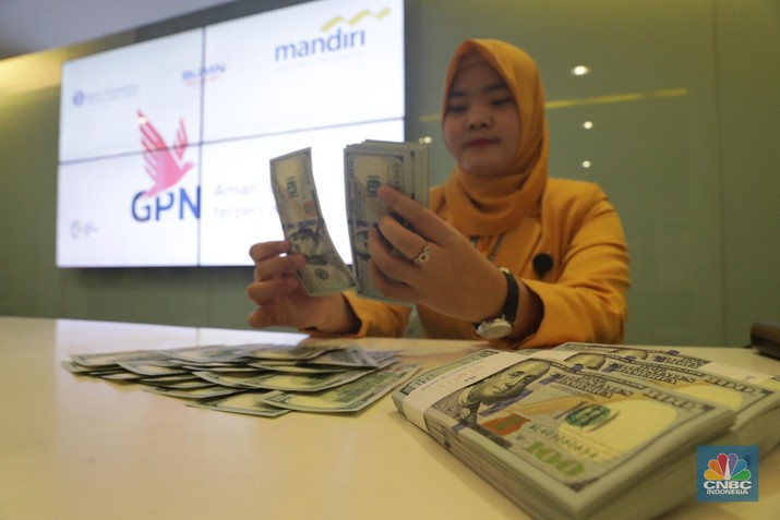 Ilustrasi Mata Uang Ilustrasi Rupiah dan Dollar di teller Bank Mandiri, Jakarta, Senin (07/5). Nilai tukar rupiah terhadap dolar Amerika Serikat (AS) masih melemah. Rupiah melemah 0,32 % dibandingkan penutupan akhir pekan lalu. Harga jual dolar AS di bank Mandiri Rp. 14.043. (CNBC Indonesia/Muhammad Sabki)