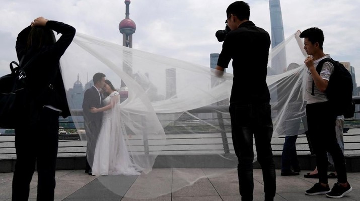 A couple prepares for their wedding photo session on the Bund in Shanghai, China May 8, 2018. Picture taken May 8, 2018. REUTERS/Aly Song