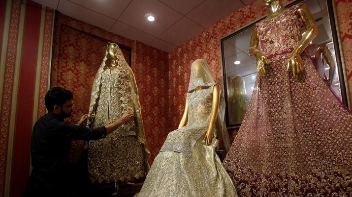 gaun pengantin A shopkeeper adjusts bridal dress on a mannequin on a display at a shop in Peshawar, Pakistan May 7, 2018. REUTERS/Fayaz Aziz