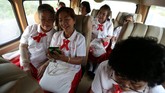Para pelajar menggunakan bus sekolah menuju sekolah lansia di Chiang Rak Noi, Ayutthaya, Thailand. Sekolah adalah salah satu cara pemerintah Thailand bisa merawat kelompok lansia. (REUTERS/Athit Perawongmetha)