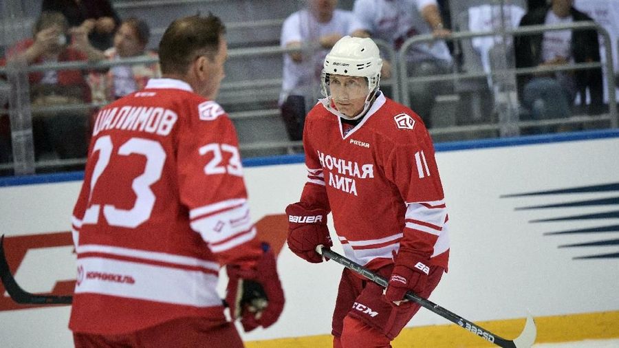 Vladimir Putin  mengenakan seragam berwarna merah dengan nomer 11