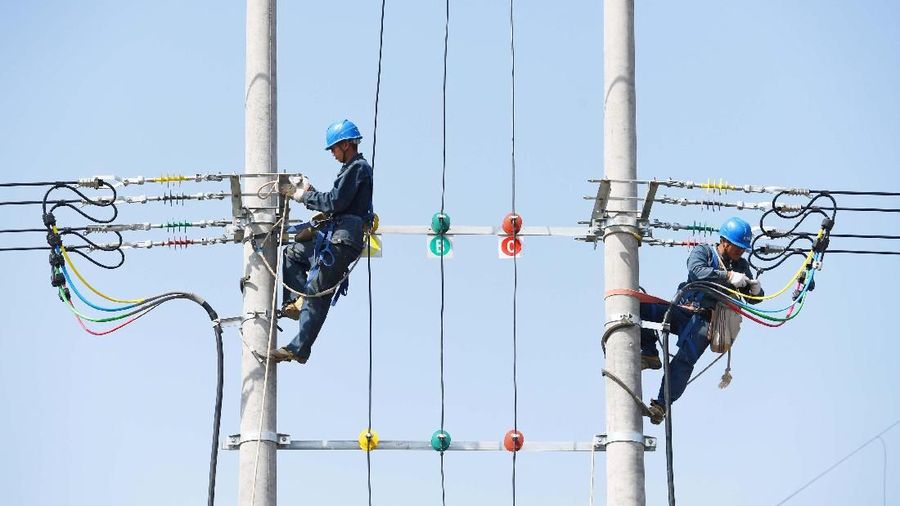 Technicians work on power cables on utility poles in Chuzhou, Anhui province, China May 10, 2018. Picture taken May 10, 2018. REUTERS/Stringer